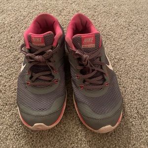 Nike women tennis shoes. Used but in good condition. Grey with pink accents, 6.5